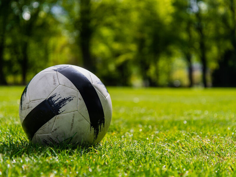 Soccer ball on green grass playground